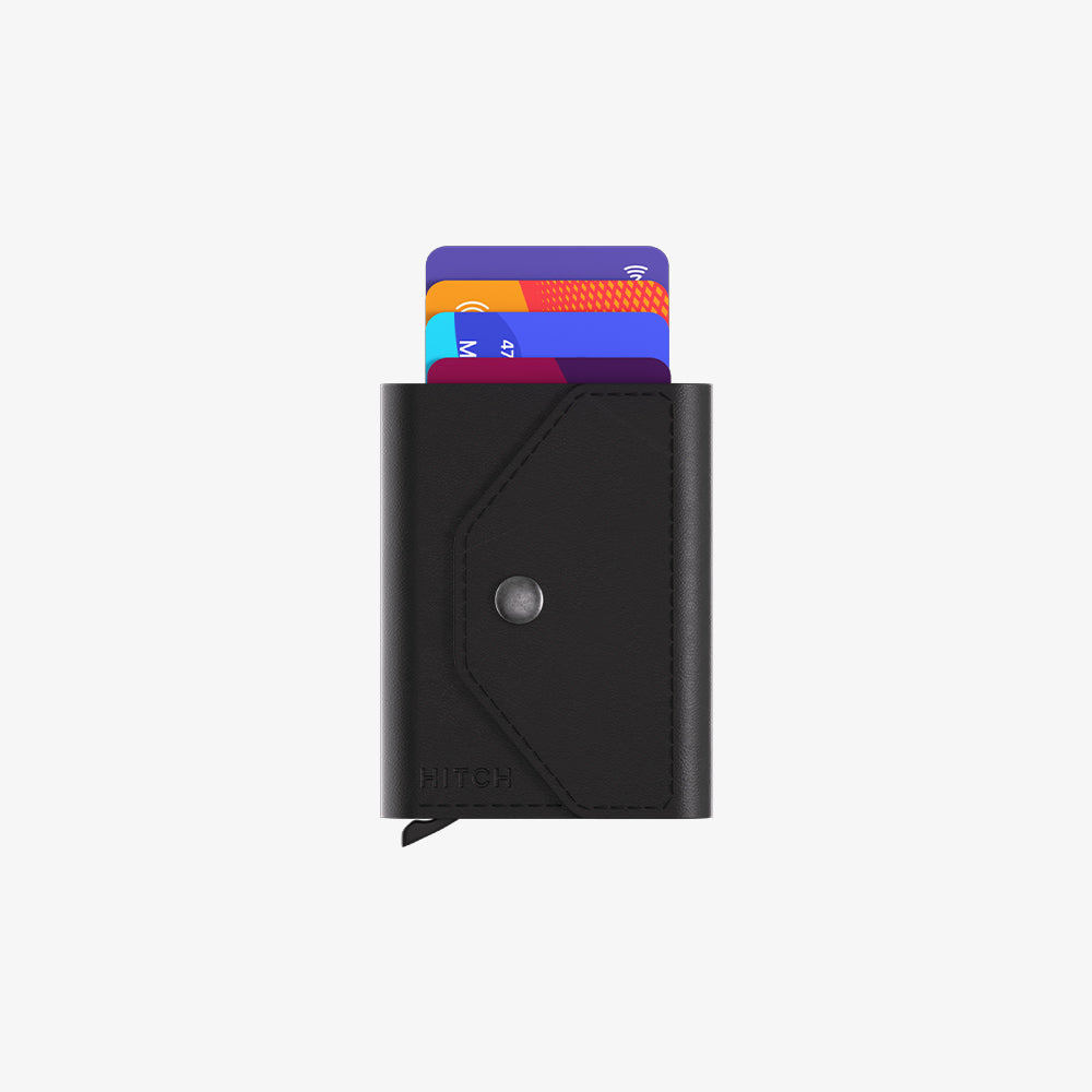 Black leather cardholder with visible credit cards and snap button closure.