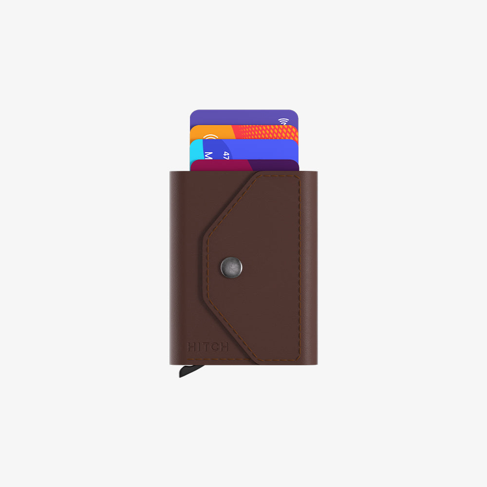 Brown leather cardholder with a snap button and credit cards peeking out.