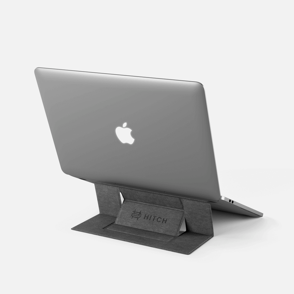 Apple MacBook on a gray Hitch laptop stand on a white background.
