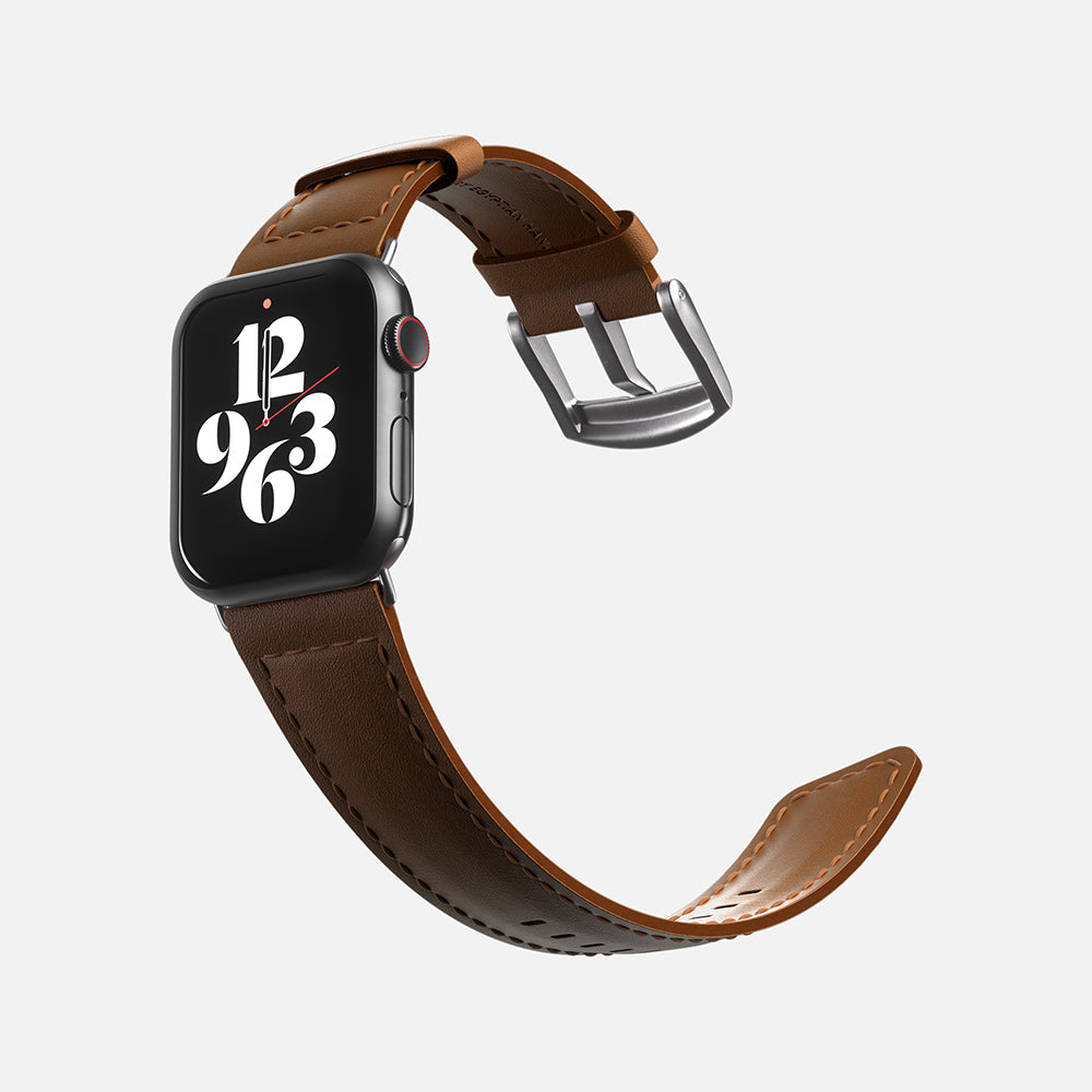 Apple Smartwatch with brown leather strap and digital clock face on white background.
