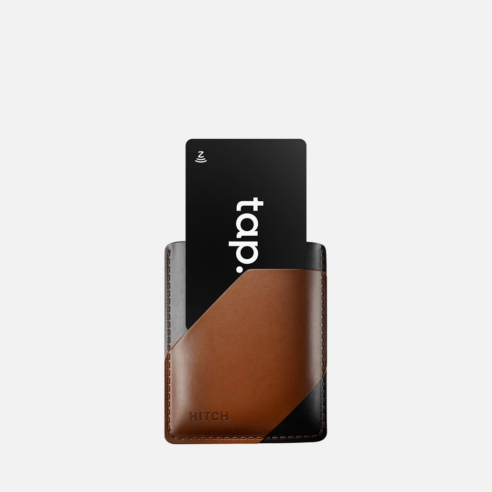 "Minimalist leather cardholder with a black contactless NFC "tap." payment card isolated on white background."