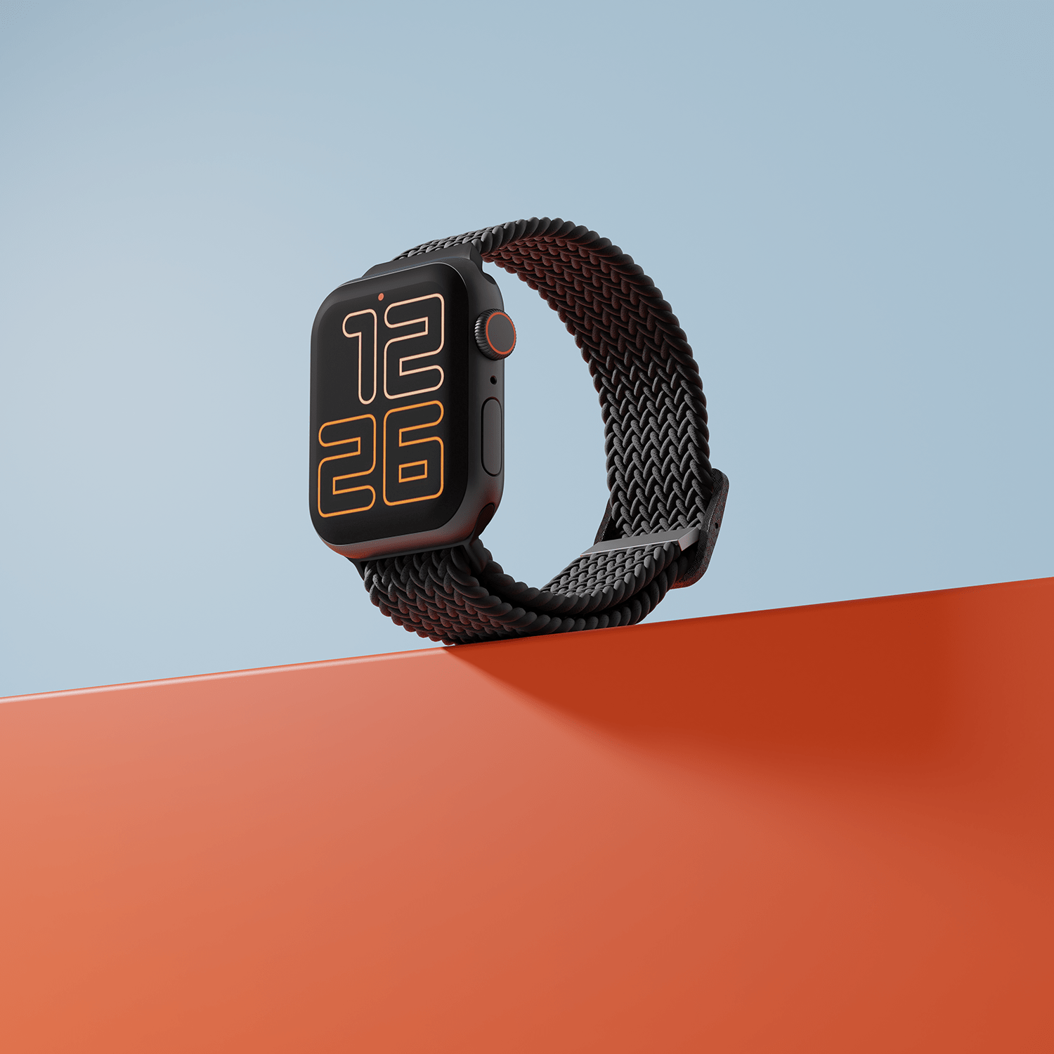 Smartwatch with braided loop on orange surface against blue background.