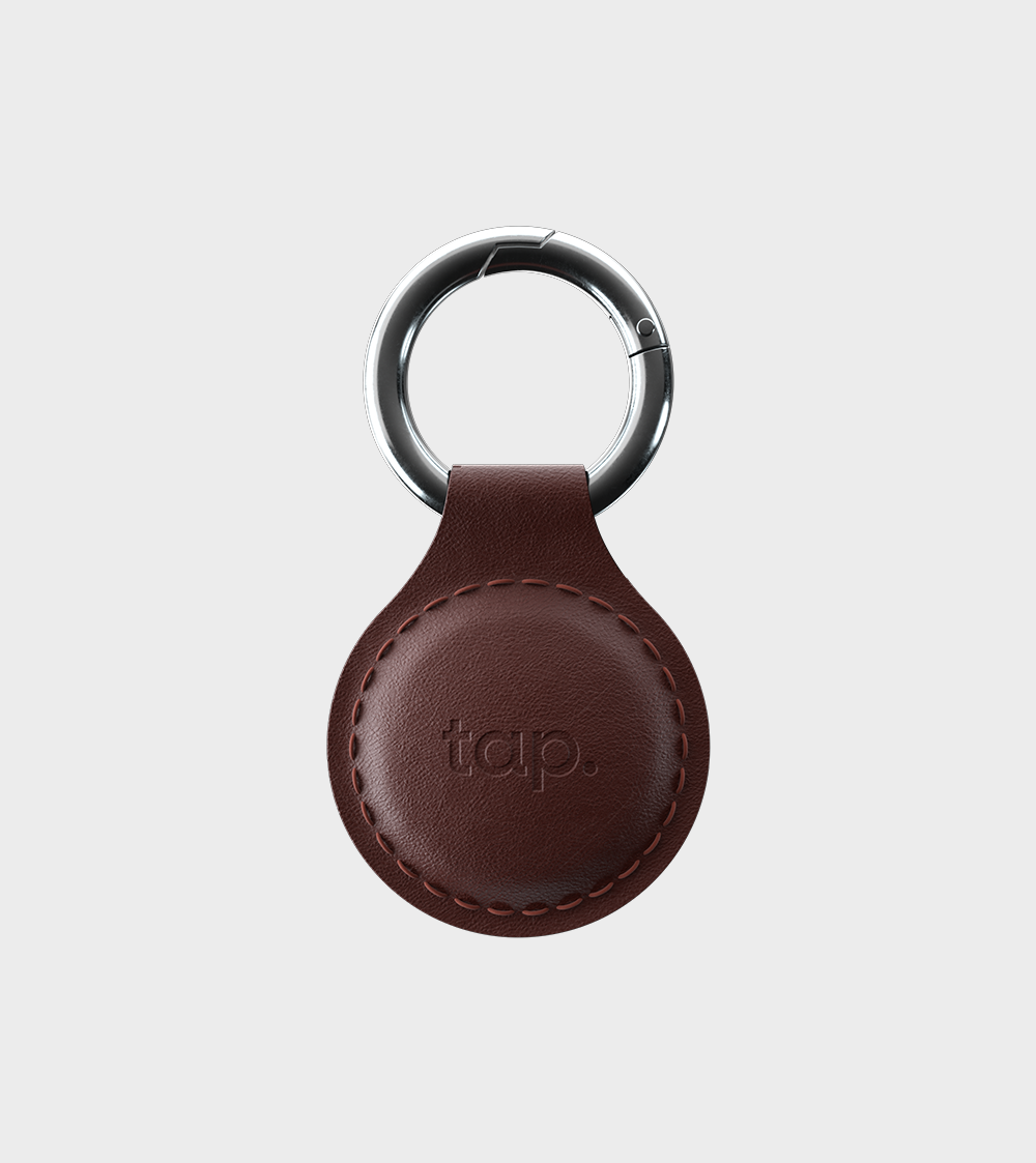Leather keychain with metal ring and embossed logo on white background.