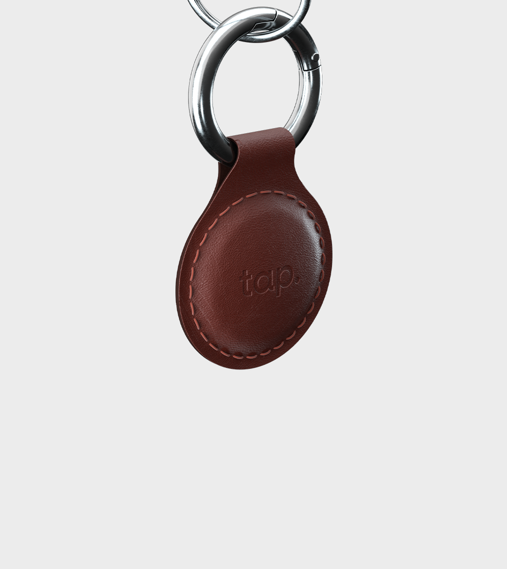 Leather key fob with metal ring and embossed branding on white background.