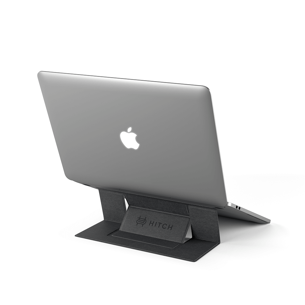 "Apple MacBook on HITCH laptop stand isolated on white background for ergonomic workspace setup."