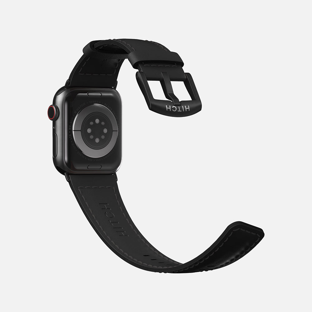 Apple smartwatch with a black leather strap and digital crown, isolated on a white background.