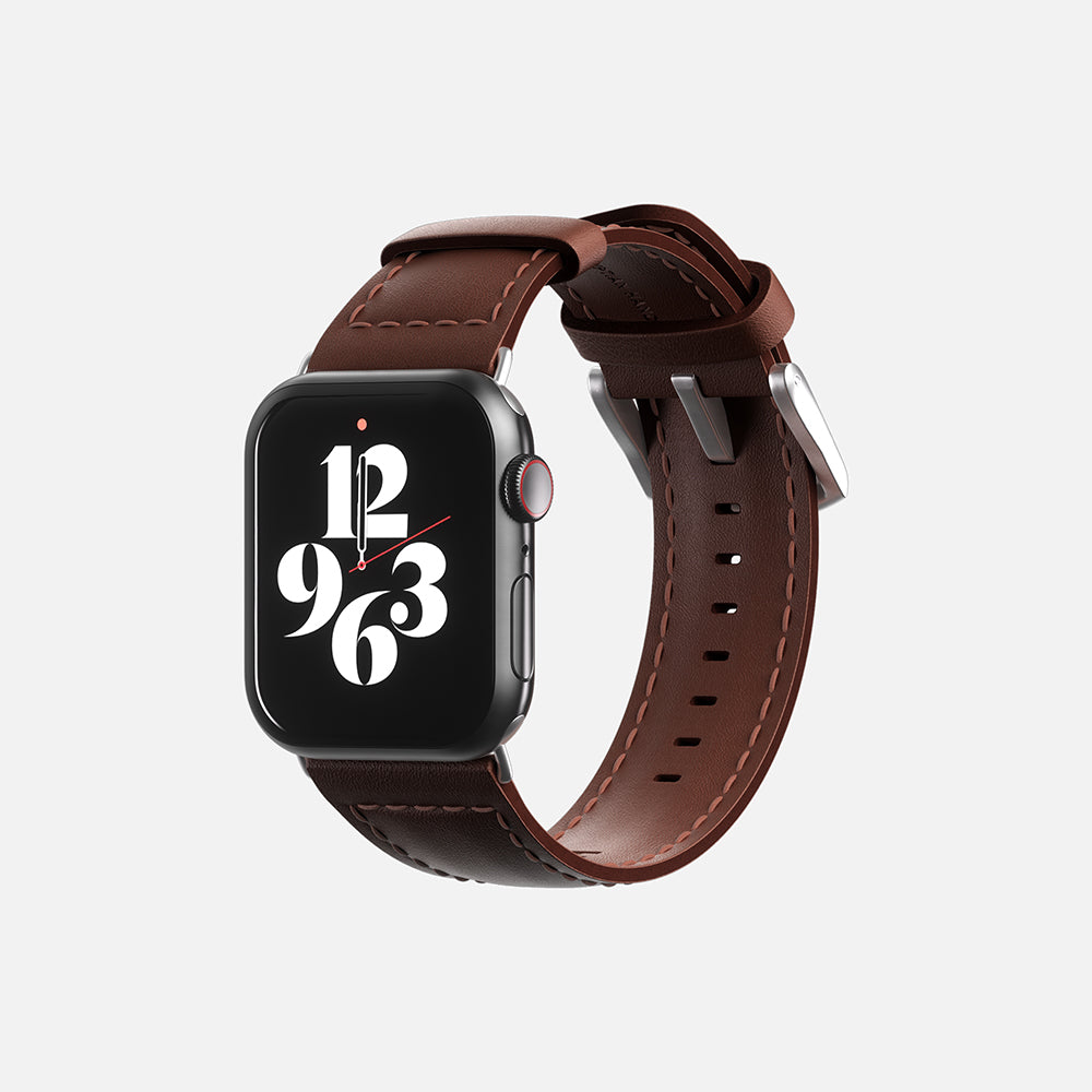 Apple Smartwatch with brown leather strap and digital face displaying time isolated on white background.