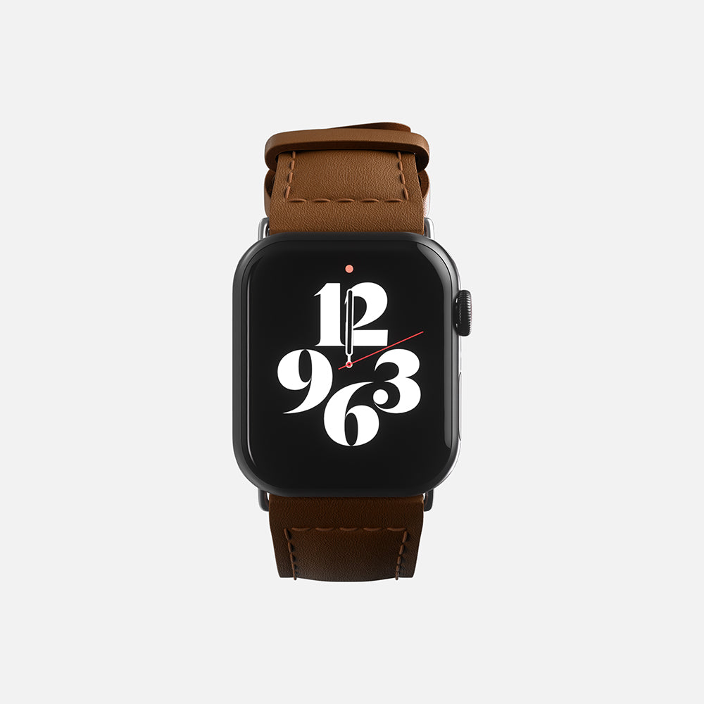 Modern Apple smartwatch with stylish numerals on display and brown leather strap.