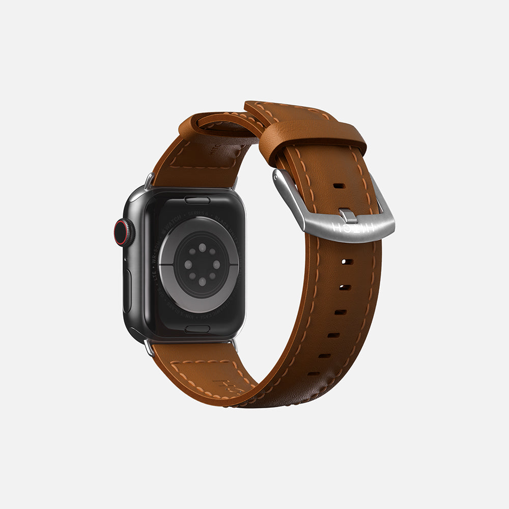 Modern Apple smartwatch with brown leather strap and digital crown on white background.
